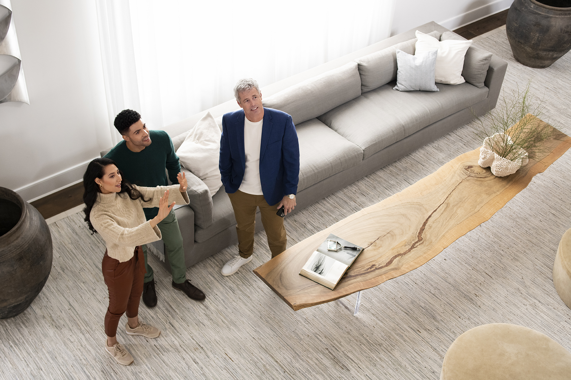 Three people are looking at the inside of a home. One appears to be an agent, and the other two are a couple.